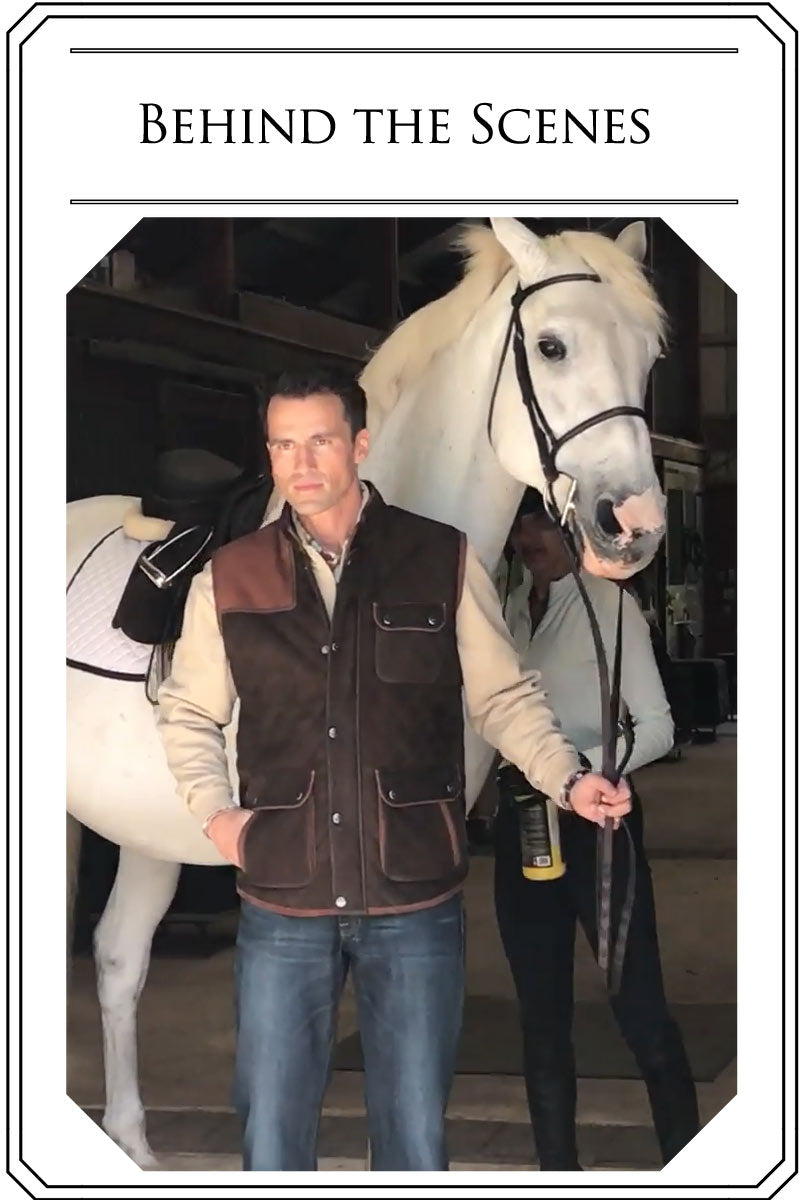Image of man in sweater and leather vest leading a horse, with text that reads "Behind the Scenes"