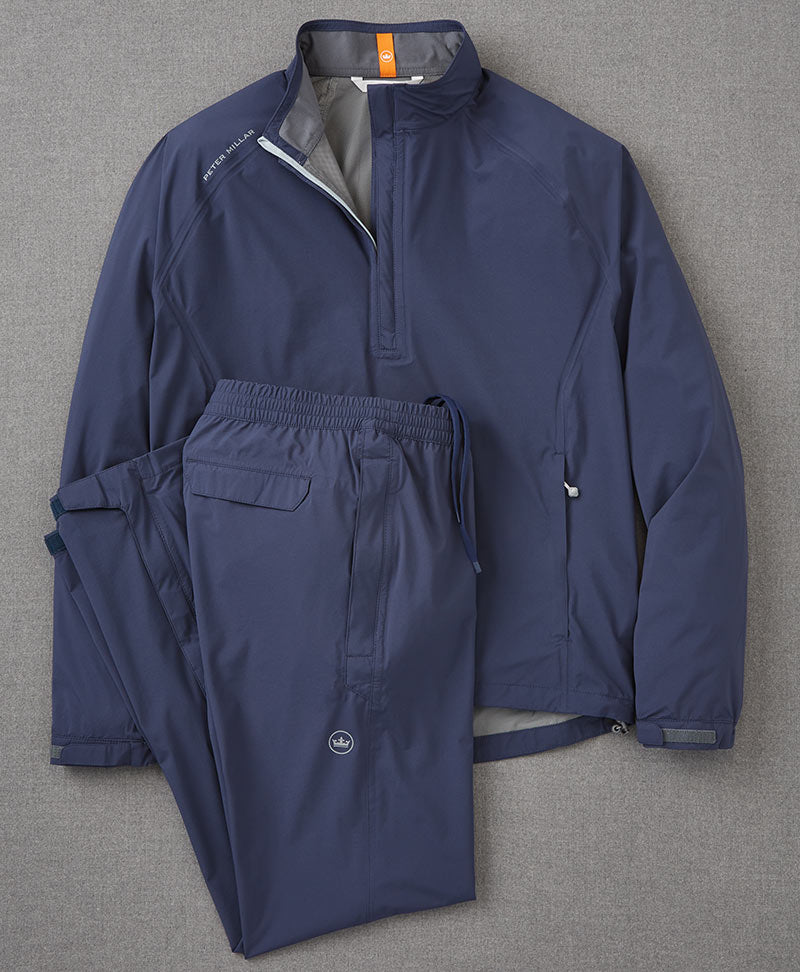 Blue pullover and pants rain gear laid on a flat surface