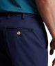 Men's navy performance pants close-up: front pocket and gold-tone button