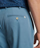 Light blue performance pant close-up: waistband, button closure, and belt loops