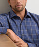 Men's performance flannel shirt, navy-blue plaid close-up with buttoned collar.